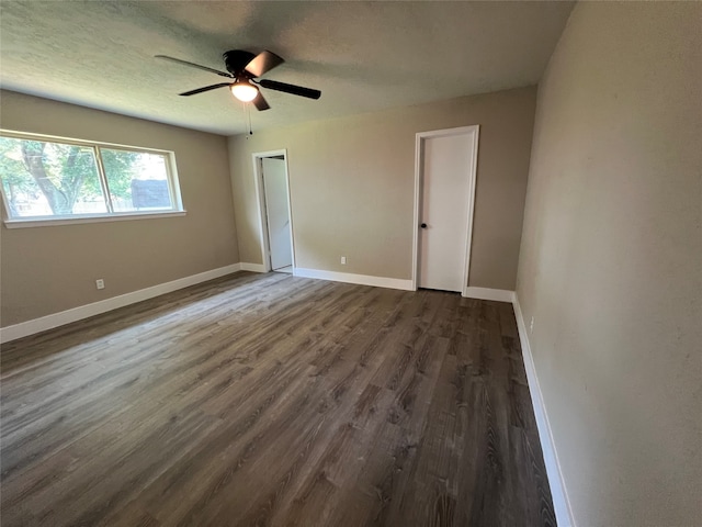 unfurnished bedroom with ceiling fan, a textured ceiling, and dark hardwood / wood-style floors