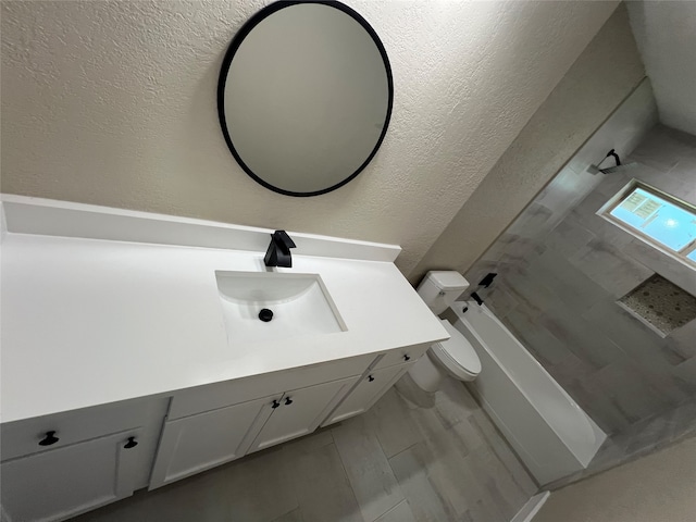 bathroom featuring vanity, a bathtub, and toilet