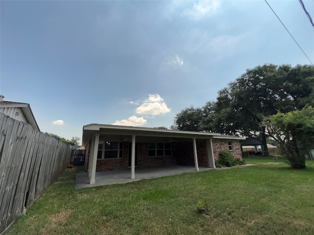 rear view of house with a patio and a lawn