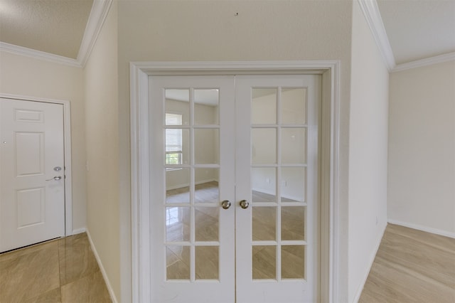 entryway featuring french doors, a textured ceiling, and ornamental molding