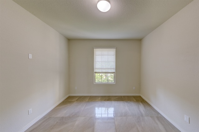 unfurnished room with a textured ceiling