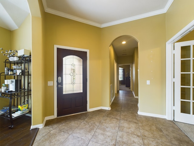 entryway featuring ornamental molding and light tile patterned floors