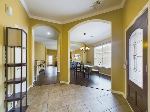 foyer entrance featuring light hardwood / wood-style floors, crown molding, and a chandelier