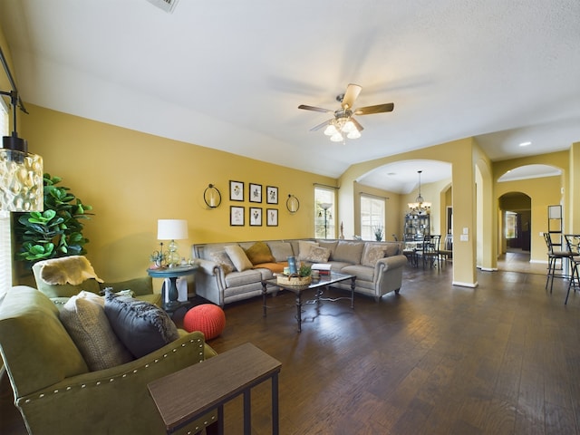 living room with ceiling fan with notable chandelier, dark wood-type flooring, and lofted ceiling