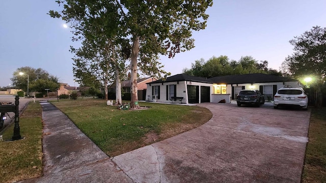 ranch-style home featuring a yard and a garage