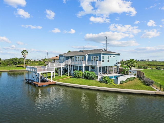 back of house with a swimming pool, a patio, a balcony, a lawn, and a water view