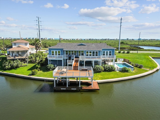 rear view of house with a water view and a yard