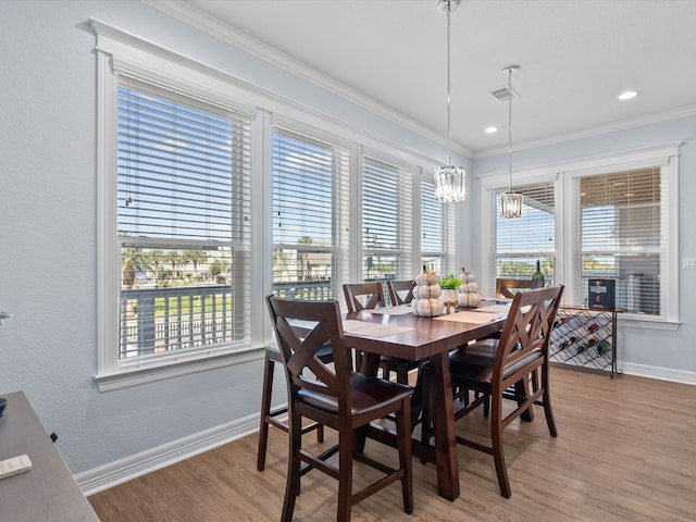 dining room featuring crown molding, hardwood / wood-style flooring, and a wealth of natural light