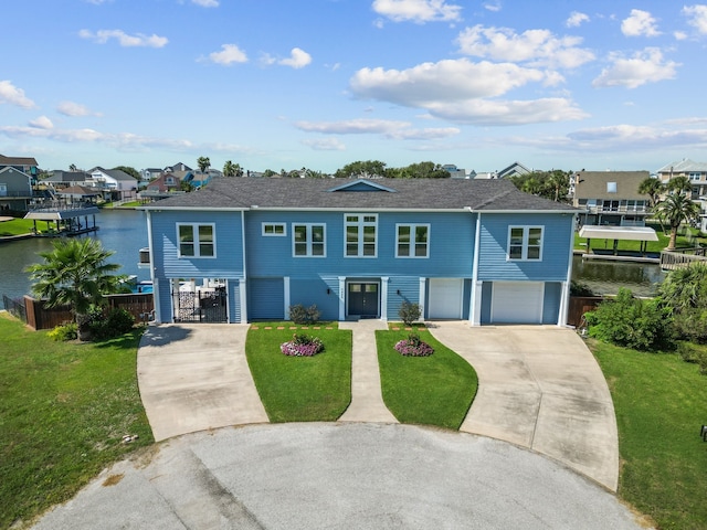 view of front of property featuring a garage, a front lawn, and a water view