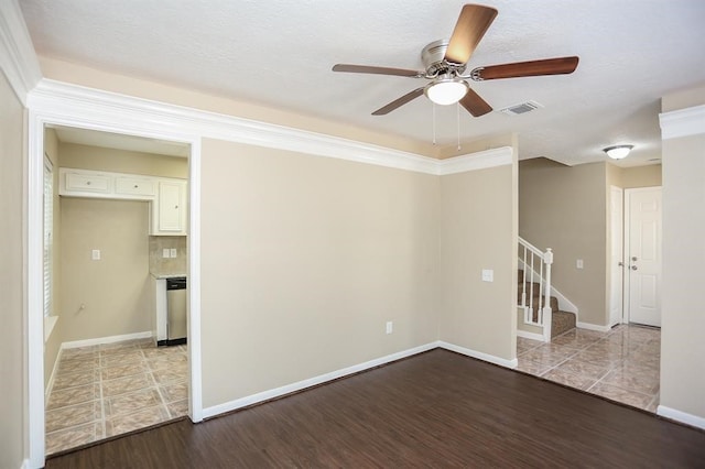 unfurnished room featuring crown molding, a textured ceiling, light wood-type flooring, and ceiling fan