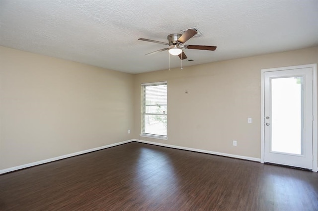 spare room with dark hardwood / wood-style floors, a textured ceiling, and ceiling fan