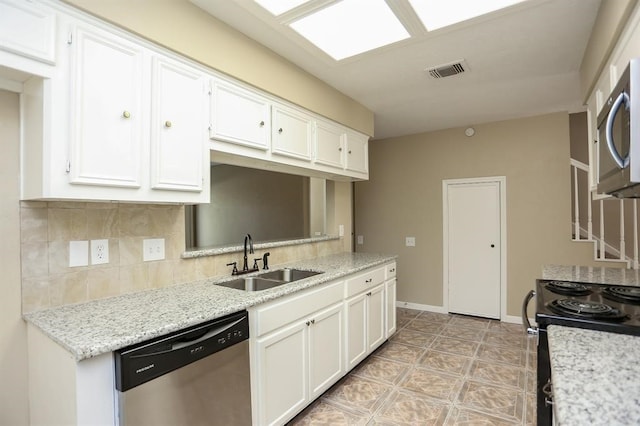 kitchen featuring light stone counters, backsplash, white cabinetry, sink, and stainless steel appliances