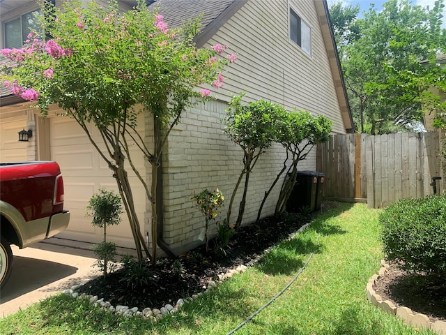 view of side of home featuring a yard and a garage