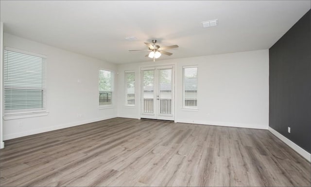 unfurnished living room with ceiling fan, french doors, and light hardwood / wood-style floors