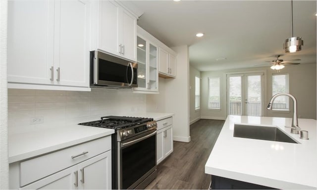 kitchen with ceiling fan, tasteful backsplash, dark wood-type flooring, sink, and appliances with stainless steel finishes