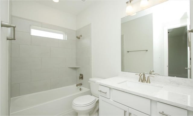 full bathroom featuring tiled shower / bath, vanity, and toilet