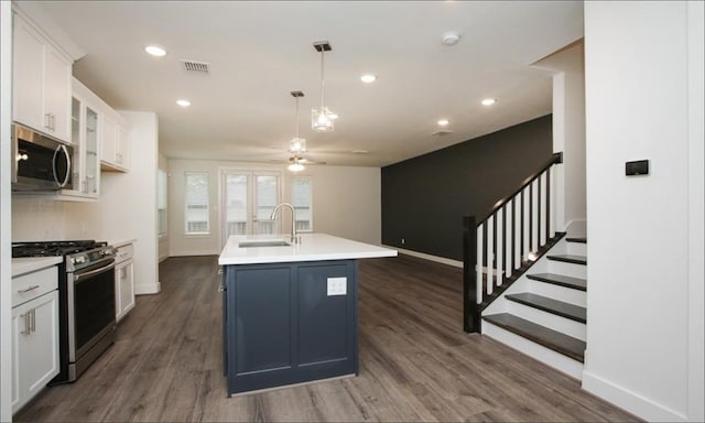 kitchen featuring an island with sink, dark wood-type flooring, sink, white cabinetry, and appliances with stainless steel finishes