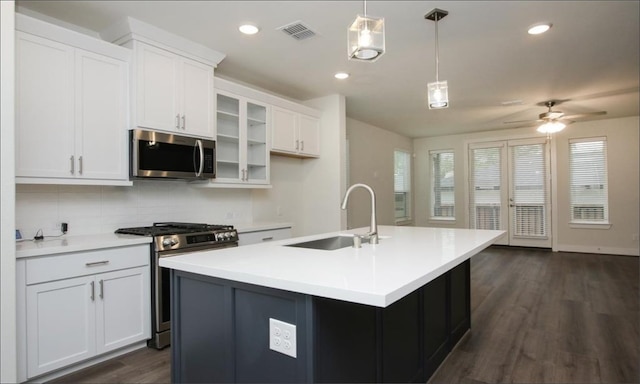 kitchen featuring white cabinets, hanging light fixtures, sink, a center island with sink, and stainless steel appliances