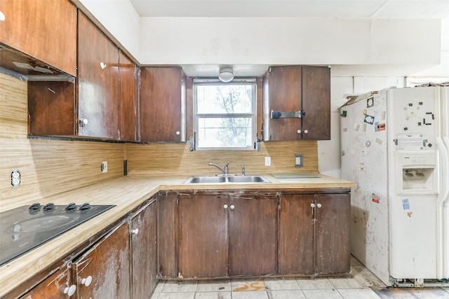 kitchen with decorative backsplash, light tile patterned floors, white fridge with ice dispenser, sink, and black electric stovetop