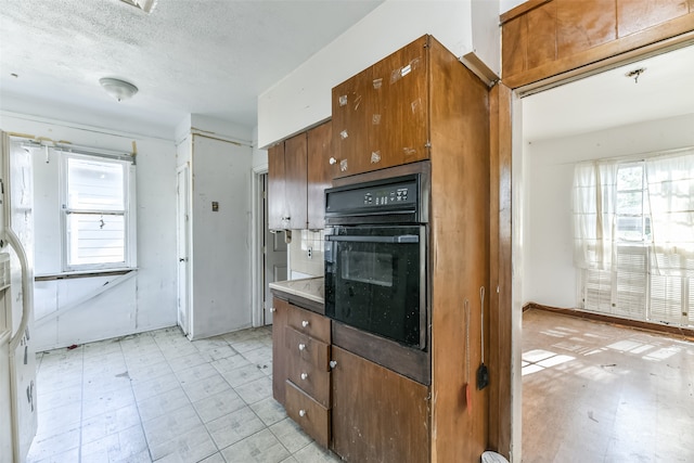 kitchen featuring oven and a textured ceiling