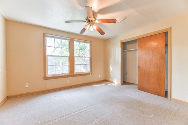 unfurnished bedroom featuring ceiling fan, a closet, and light colored carpet