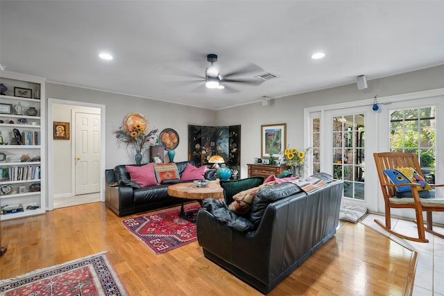 living room with french doors, built in features, light hardwood / wood-style floors, and ceiling fan