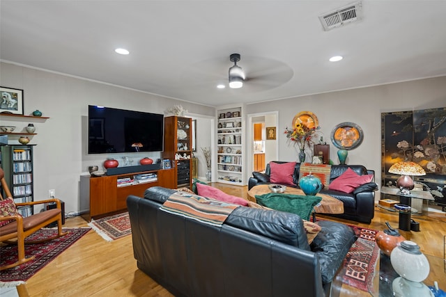 living room with crown molding, ceiling fan, and wood-type flooring