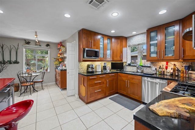 kitchen featuring tasteful backsplash, appliances with stainless steel finishes, sink, and light tile patterned floors