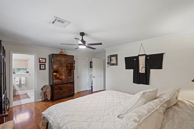 bedroom with ensuite bath, crown molding, ceiling fan, and wood-type flooring