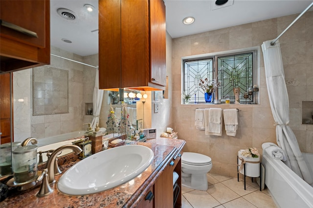 full bathroom with tile walls, shower / bath combo, vanity, and toilet