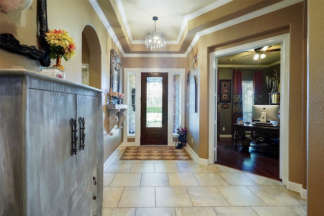 foyer featuring light hardwood / wood-style flooring, a tray ceiling, ceiling fan with notable chandelier, and crown molding