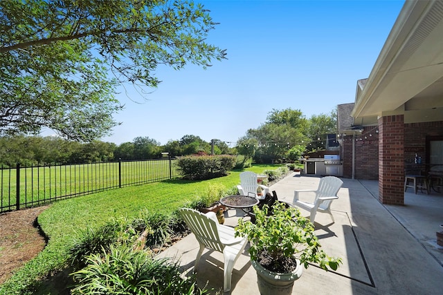 view of patio with an outdoor kitchen and a fire pit