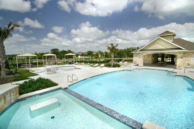 view of pool featuring a patio and a hot tub