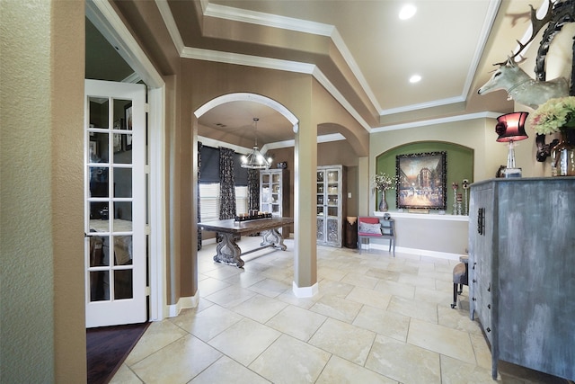 entryway featuring an inviting chandelier and crown molding