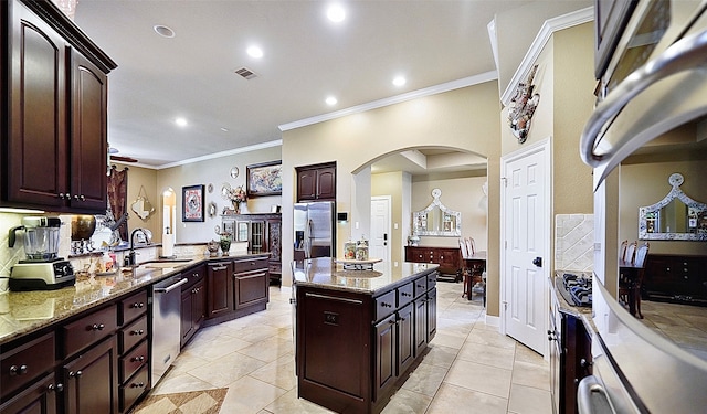 kitchen with ornamental molding, sink, and dark brown cabinets