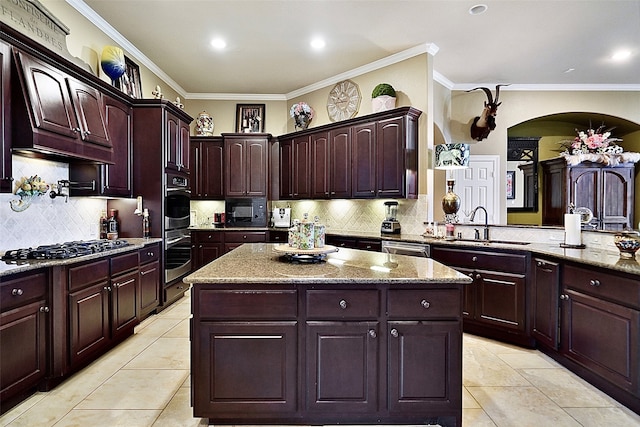 kitchen featuring sink, a kitchen island, backsplash, light stone counters, and crown molding