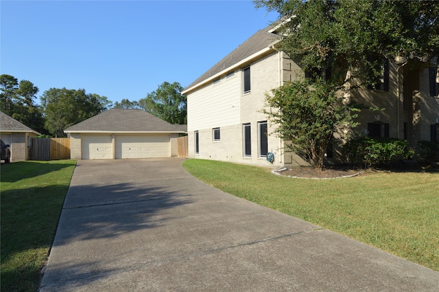 view of side of property with a lawn, a garage, and an outbuilding