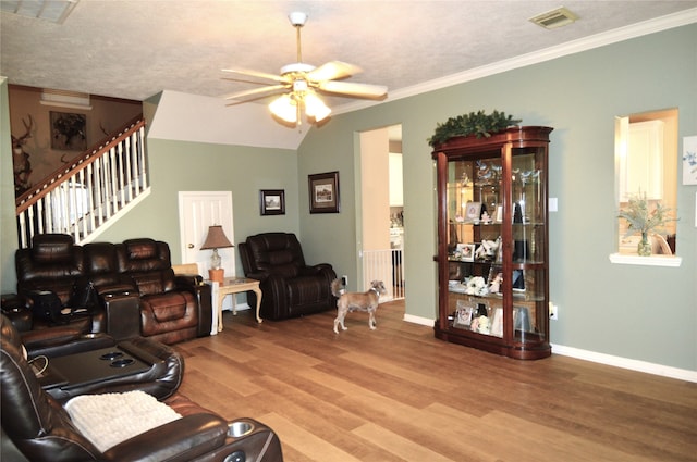 living room featuring ceiling fan, crown molding, lofted ceiling, and light wood-type flooring