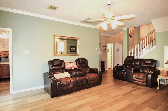 cinema room featuring ceiling fan, light hardwood / wood-style flooring, and ornamental molding