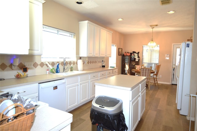 kitchen featuring plenty of natural light, white cabinetry, a center island, and white appliances