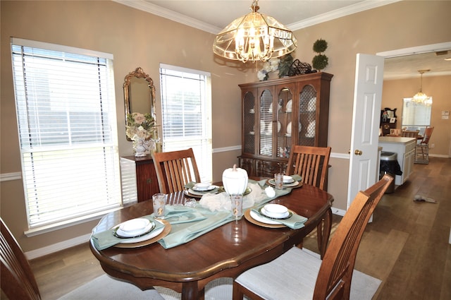 dining area with an inviting chandelier, dark wood-type flooring, and crown molding