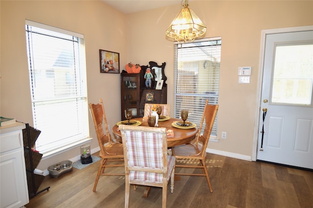 dining area featuring a wealth of natural light, hardwood / wood-style floors, and a notable chandelier