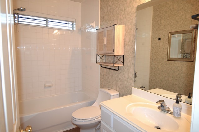 full bathroom featuring vanity, tiled shower / bath, and toilet