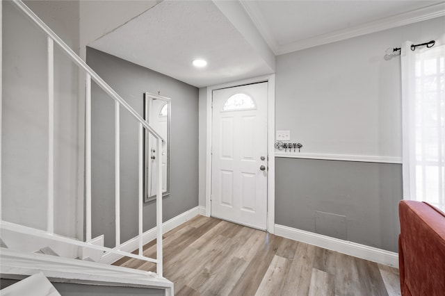 entrance foyer with crown molding and light hardwood / wood-style flooring