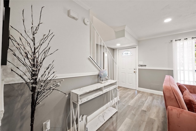 entryway featuring ornamental molding and light hardwood / wood-style flooring