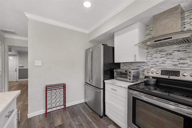 kitchen with wall chimney range hood, white cabinets, dark hardwood / wood-style floors, crown molding, and stainless steel appliances