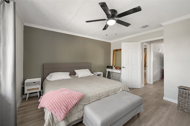 bedroom with ornamental molding, a textured ceiling, light wood-type flooring, and ceiling fan