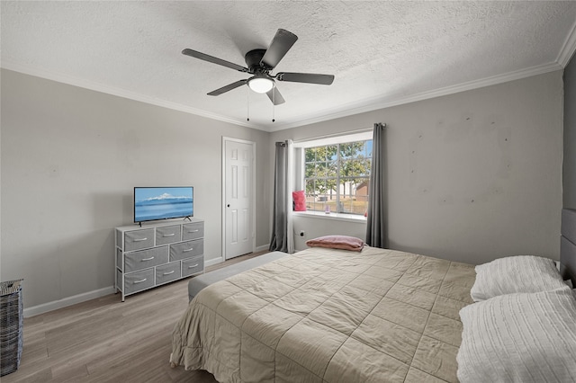 bedroom featuring light hardwood / wood-style floors, ornamental molding, a textured ceiling, and ceiling fan