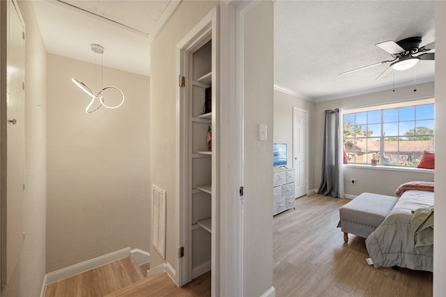 bedroom featuring ornamental molding, light wood-type flooring, and ceiling fan