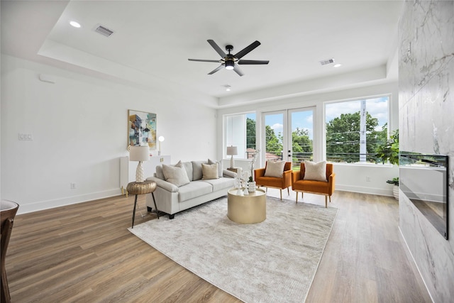 living room featuring wood-type flooring, french doors, and ceiling fan